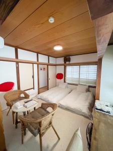 a room with a bed and a table and chairs at Kikusui Ryokan in Tamano