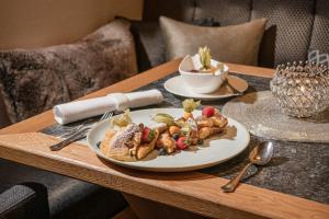 a table with a plate of food on a table at Alpines Lifestyle Hotel Tannenhof in Sankt Johann im Pongau