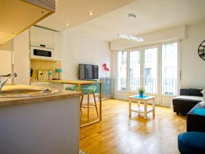 a kitchen and living room with a couch and a table at Loft 4/6 pers proximité centre ville, gare et tram in Caen