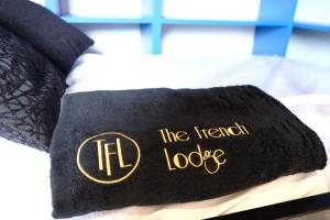 Una toalla negra con la cabaña francesa escrita en una cama en Suite Yellowstone en Peisey-Nancroix