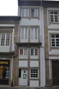 un edificio alto con ventanas blancas y balcones. en Casa Augusta AL en Braga