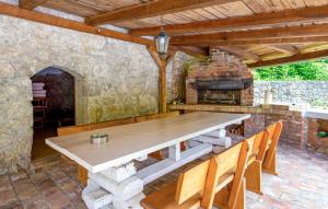 a wooden table and chairs on a patio with an oven at Villa Natura in Poljane