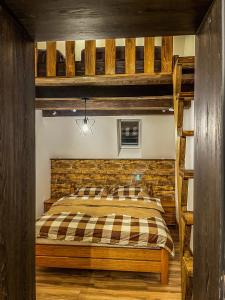 ein Schlafzimmer mit einem Etagenbett mit Ziegelwand in der Unterkunft Vila Bašić Vlašić Apartman VUK in Vlasic
