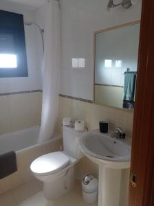 W łazience znajduje się toaleta, umywalka i lustro. w obiekcie Casa sol Origo Mare w mieście Lajares