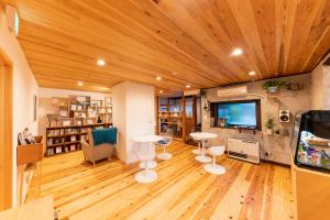 ein Wohnzimmer mit einem Tisch und einem TV in der Unterkunft 深々 books&stay シンシンブックスアンドステイ in Matsukawa