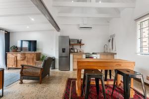 a kitchen with a wooden table and chairs in a room at Dolphin Coast Doll House - quaint cottage close to the beach! in Salt Rock