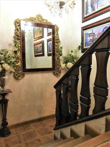 uma escada com pinturas e um espelho na parede em La Casa dels Poetes em Santa Pau