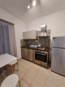 a kitchen with a stainless steel refrigerator and a table at Aqua Apartments in Loutra Oraias Elenis