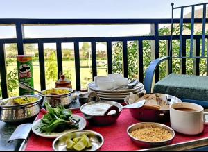 una mesa llena de comida en el balcón en The Sariska Retreat en Thāna Ghāzi