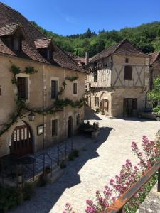 a row of buildings in a courtyard with flowers at Le Mas des 3 Anes in Blars