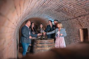 Un groupe de gens autour d'un tonneau de vin dans l'établissement Winzerhof Küssler - Weinviertel, à Stillfried