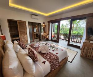 a living room with a large bed and a couch at Pinggala Villa Ubud in Gianyar