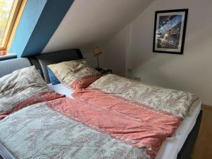 a bed with a red blanket on it in a bedroom at Nettes Appartment in Langenhagen in Hannover