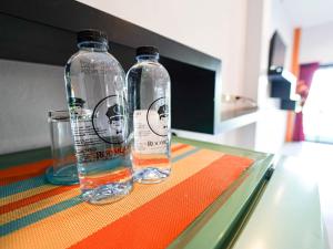 two bottles of water sitting on top of a table at RoomQuest Chonburi Phanat Nikhom in Ban Noen Rae