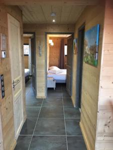 a hallway of a cabin with a bedroom and a bed at Bottières in Saint-Pancrace