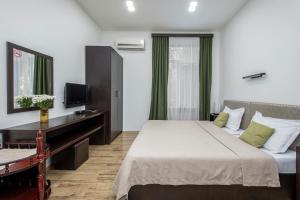 une chambre d'hôtel avec un lit et une télévision dans l'établissement Apart Hotel GH, à Tbilissi