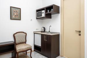 cocina pequeña con silla y microondas en Apart Hotel GH, en Tiflis