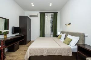 a hotel room with a bed and a television at Apart Hotel GH in Tbilisi City +16 photos