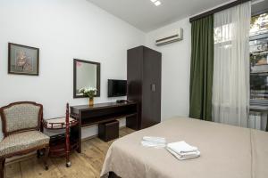 a hotel room with a bed and a desk and a chair at Apart Hotel GH in Tbilisi City