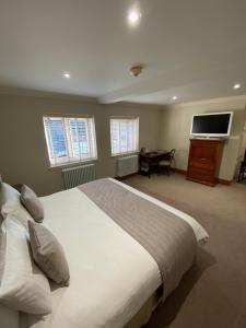 a bedroom with a large bed and a flat screen tv at Dalston Hall in Carlisle