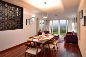 a dining room and living room with a table and chairs at StayVista at The Lilly with Breakfast & Yoga in Ooty