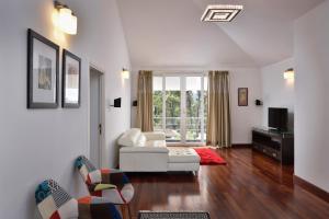 a living room with a white couch and a tv at StayVista at The Lilly with Breakfast & Yoga in Ooty