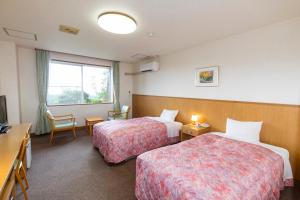 a hotel room with two beds and a television at Kyukamura Chausuyama-Kogen in Toyone +73 photos