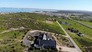 an aerial view of a house on a hill next to the ocean at Hook Wine And Sinker in Langebaan