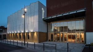 a large building with a lit up facade at night at Studio D Cosy Parc des expositions Roissy CDG Airport in Vaujours