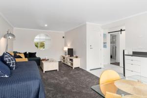 a living room with a bed and a couch at River Rest - Ruakaka Holiday Home in Ruakaka