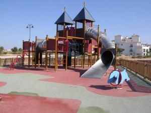 a playground with a slide in a park at Apartment in Hacienda Riquelme Golf Resort in Sucina