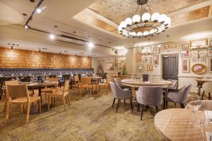 a restaurant with tables and chairs and a chandelier at The Wynnstay Hotel, Oswestry, Shropshire - The Coaching Inn Group in Oswestry +58 photos