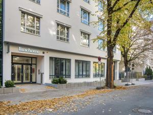 un edificio bianco con un albero di fronte di limehome Berlin Luise Henriette Str - Digital Access a Berlino