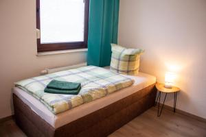 ein kleines Bett in einem Zimmer mit Fenster in der Unterkunft Exklusives Apartment für 1 bis 3 Personen in Solingen