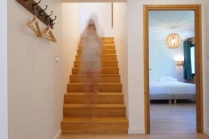 Une personne monte un escalier dans une pièce dans l'établissement L'Etincelle Mountain Lodge, à Chamrousse