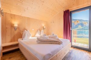 a bedroom with a bed with towels on it at Bergeralm Chalets by ALPS RESORTS in Steinach am Brenner