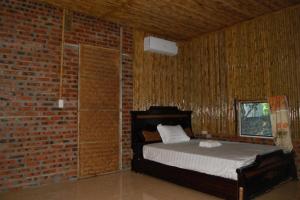um quarto com uma cama numa parede de tijolos em Ninh Binh Bungalow Homestay em Ninh Binh