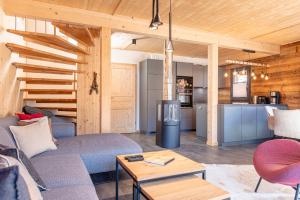 ein Wohnzimmer mit einem Sofa und einem Tisch in der Unterkunft Bergeralm Chalets by ALPS RESORTS in Steinach am Brenner