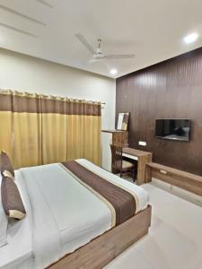 um quarto com uma cama, uma secretária e uma televisão em Raj Darbar - 10 Meter From Golden Temple em Amritsar