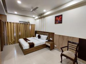 a bedroom with a bed and a chair at Raj Darbar - 10 Meter From Golden Temple in Amritsar