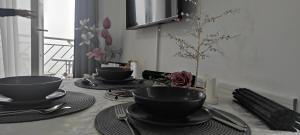 迪夫伊拜的住宿－Divcibare As apartmani，一张桌子,上面放着两个黑碗和盘子