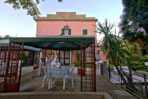 a table and chairs under an umbrella on a balcony at Villa Very in Marina di Campo