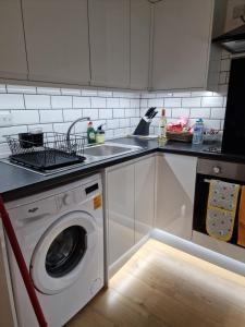 a kitchen with a washing machine in the floor at Balco Sherwood House - 2 Bedrooms, 5 beds - Sky tv and internet in Nottingham