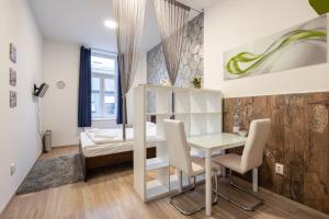 ブダペストにあるSilver Moon Apartment in the city centerのテーブル、椅子、ベッドが備わる小さな客室です。
