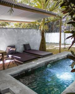 a pool in a backyard with a couch and a table at Nativ Lodge and Spa in Mahébourg