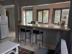 a kitchen with a counter with two stools at Bougainvillea BNB in Durban
