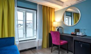 a room with a desk and a chair and a mirror at Thon Hotel Kristiansund in Kristiansund