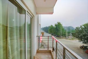 新德里的住宿－FabExpress Taj Home Stay，享有街道景色的建筑阳台
