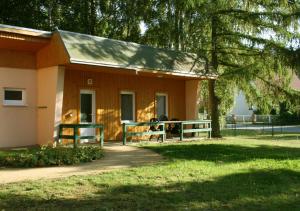 a small house with two people sitting on a porch at DAS HUDEWALD Hotel & Resort in Ueckeritz