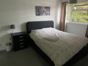 a bedroom with a bed and a dresser and a window at Corporate Large Modern 4 to 5 Bedroom House in Bishops Stortford